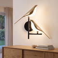 Golden birdlight wall lamp in a living room above an oak sideboard