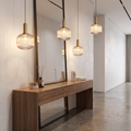 Striped glass pendant light in a hallway above a console table
