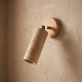 Travertine and wood wabi-sabi wall lamp on a textured plaster wall