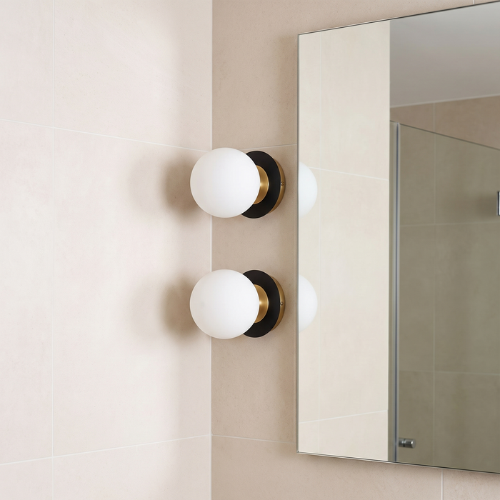 Nordic globe glass wall lamp beside a bathroom mirror